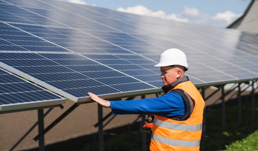 Solar power plant worker checks the condition of the panels