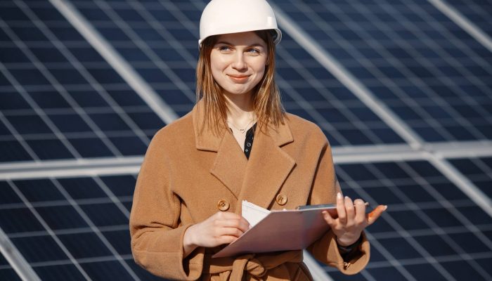 Businesswomen working on checking equipment at solar power plant. With tablet checklist, woman working on outdoor at solar power.